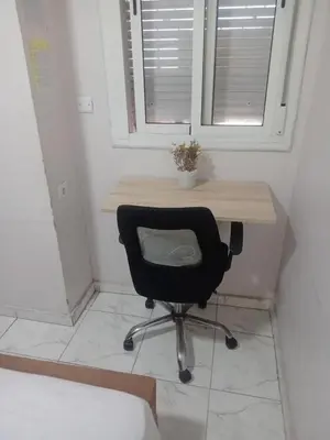 a desk with a black chair in a room at Appartement moderne et confortable proche plages in Casablanca