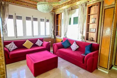 a living room with two red couches in a room at The 5-Suite Beachfront Villa in O Ben Slimane