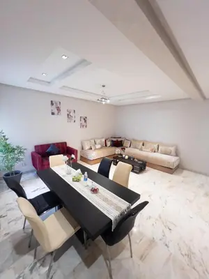 a dining room with a table and chairs and a couch at Family Apartment à Jnane California Confort & Proximité in Casablanca