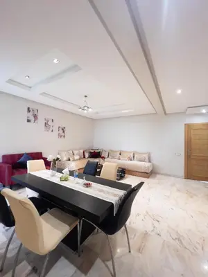 a living room with a table and a couch at Family Apartment à Jnane California Confort & Proximité in Casablanca