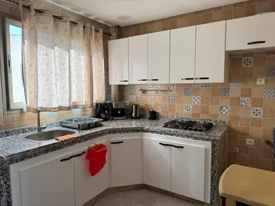 a kitchen with white cabinets and a sink at Appartement arome in Rabat