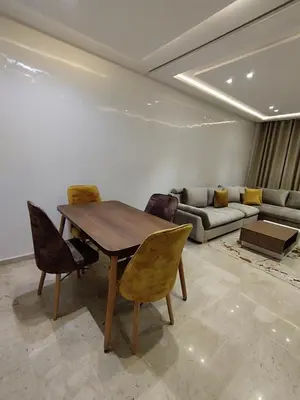 a living room with a wooden table and chairs at Rosa Luxury Apartment , Confort, Vue Dégagée , Parking Privé près du CFC in Casablanca