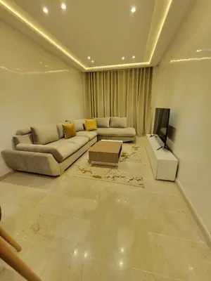 a living room with a couch and a tv at Rosa Luxury Apartment , Confort, Vue Dégagée , Parking Privé près du CFC in Casablanca