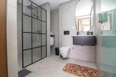 a bathroom with a shower and a toilet and a sink at Beautiful Studio in Oasis - Gym access & Balcony & Free Parking & Wifi Fiber in Casablanca
