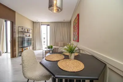 a living room with a table and chairs at Beautiful Studio in Oasis - Gym access & Balcony & Free Parking & Wifi Fiber in Casablanca