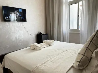 a bedroom with a bed with a tv on the wall at Lalla Mina Suite with large Terrace - Dar EL BAHIA in Casablanca