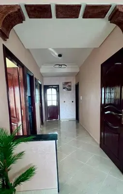 an empty room with a hallway with doors and a plant at Superbe T3 ensoleillé avec Terrasse - 2 chambres - Casablanca in Casablanca