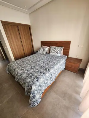 a bedroom with a bed with a wooden headboard at Apparemment de détente in Mansouria