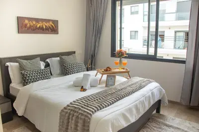 a bedroom with a large bed with a table on it at VIVASTAY Casablanca - Charming Studio Nouacer - 4 min Airport Mohamed V CMN in Nouaseur