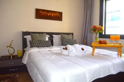 a large bed with white sheets and pillows in a bedroom at VIVASTAY Casablanca - Charming Studio Nouacer - 4 min Airport Mohamed V CMN in Nouaseur