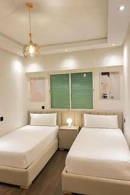 two beds sitting next to each other in a bedroom at Chic, well-equipped apartment in a perfect location in Temara