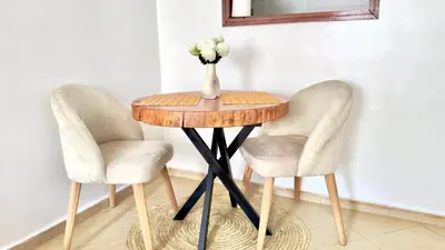 a table with two chairs and a vase with flowers on it at Charming City Retreat in Agdal - Walk to Train Station in Rabat