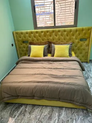 a bedroom with a large bed with yellow pillows at Appartment calme a Ain Aouda in Aïn el Apuda