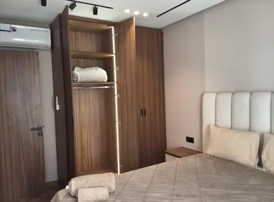 a bedroom with a bed and a wooden closet at Bsmilah in Rabat