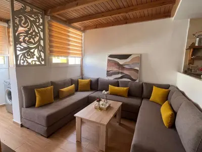 a living room with a gray couch and yellow pillows at Superbe appartement à l'Agdal in Rabat