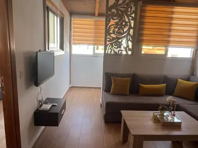 a living room with a couch and a tv at Superbe appartement à l'Agdal in Rabat