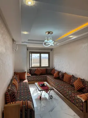 a living room with a large couch and a table at Appartement à Dahomey - Bouznika in Bouznika