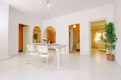 a white dining room with a white table and chairs at Casa Nova Maison moderne à deux pas de la plage in Bouznika