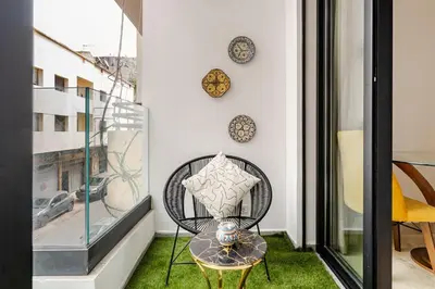 a balcony with a chair and a table and a window at 1- Bourgogne City Escape in Casablanca