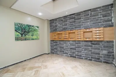 a room with a brick wall and a painting at Calme & Cocon Apartment Near Airport in Nouaceur