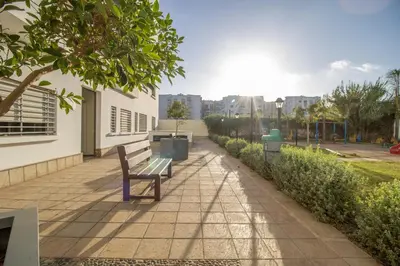 a bench sitting on a sidewalk next to a building at Calme & Cocon Apartment Near Airport in Nouaceur