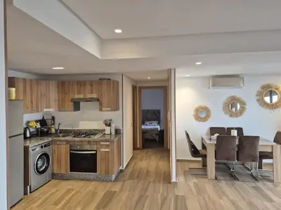 a kitchen and dining room with a table and a dining room at Appart pour Famille balnéaire Accés direct à la Mer in Sidi Rahal