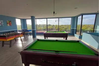 a billiard room with a pool table and some windows at Appart pour Famille balnéaire Accés direct à la Mer in Sidi Rahal