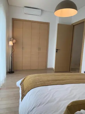 a bedroom with a large bed and a lamp at Villa Moderne et élégante Piscine Golf Resort in Casablanca