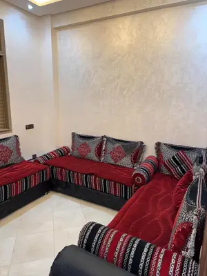 a living room with two red couches with pillows at 3 bedroom apartment with living room and terrace 90metre in El Harhoura