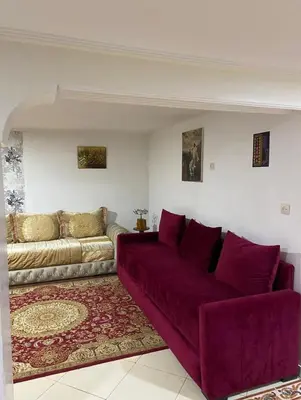 a living room with a purple couch and a rug at Floor Villa rent in El Harhoura