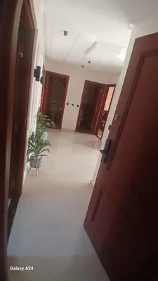 a hallway with a door and a potted plant at Résidence yassine in Rabat