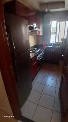 a kitchen with a black refrigerator and a stove at Résidence yassine in Rabat