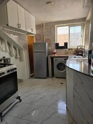 a kitchen with a refrigerator and a dishwasher at Appartement villa in Temara
