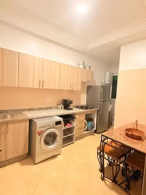 a kitchen with a washer and a dishwasher at Appartement Sidi Rehal beach in Sidi Rahal