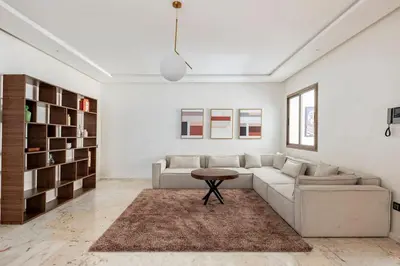 a living room with a couch and a table at Appartement neuf et moderne à l'Agdal, 2 chambres in Rabat