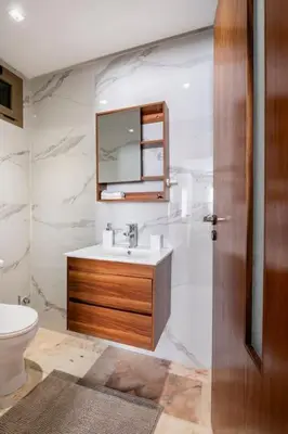 a bathroom with a sink and a toilet and a mirror at Appartement neuf et moderne à l'Agdal, 2 chambres in Rabat