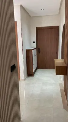 an empty room with a wooden door and a hallway at Résidence Beach Land El Mansouria in Mohammedia