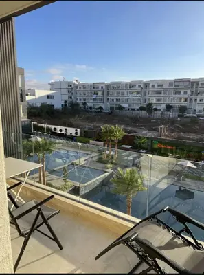 a balcony with chairs and a view of a building at Résidence Beach Land El Mansouria in Mohammedia