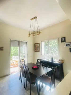 a dining room with a black table and chairs at Stunning Sunny Villa, near airport in Derroua