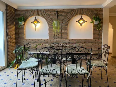 a room with tables and chairs and a brick wall at Marrakech atmosphere in Casablanca in Casablanca