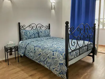 a bedroom with a bed with a blue and white comforter at Marrakech atmosphere in Casablanca in Casablanca