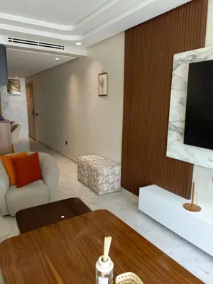 a living room with a couch and a television at Palmier house for family only in Maarif