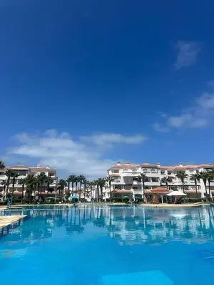 a large blue swimming pool with buildings in the background at New and cosy appt for rent in Sidi Rahal