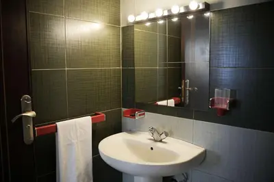 a bathroom with a sink and a mirror at Cozy Apartment in the Heart of Bouznika in Bouznika