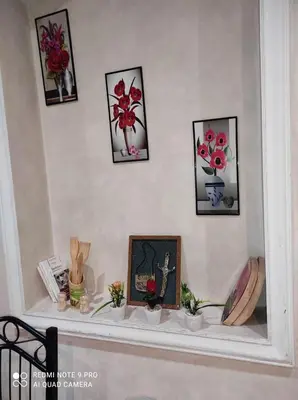 a shelf with flowers and pictures on a wall at اقامة فال دانفا in Casablanca