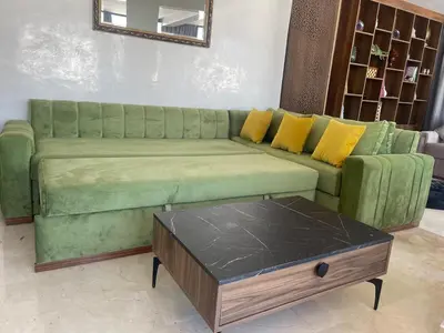 a green couch with yellow pillows and a coffee table at Spacious Apartment with Panoramic Ocean Views in Casablanca