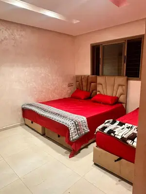 a bedroom with two beds with red sheets at Belle villa spacieuse et calme avec piscine à 7min de la plage en voiture in Tamaris