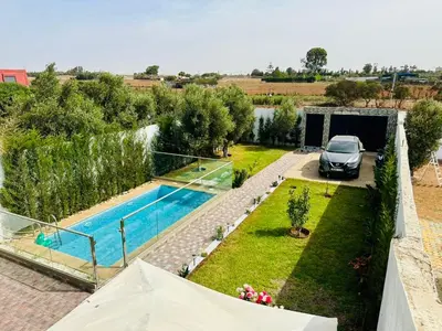 a villa with a swimming pool and a car at Belle villa spacieuse et calme avec piscine à 7min de la plage en voiture in Tamaris