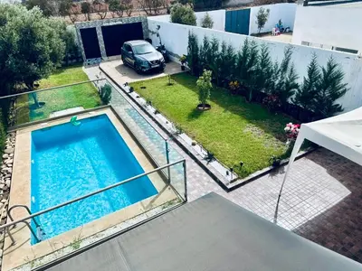 an aerial view of a backyard with a swimming pool at Belle maison avec piscine à 7 min de la plage en voiture in Dar Bouazza