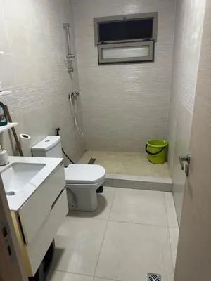 a white bathroom with a toilet and a sink at Belle maison avec piscine à 7 min de la plage en voiture in Dar Bouazza